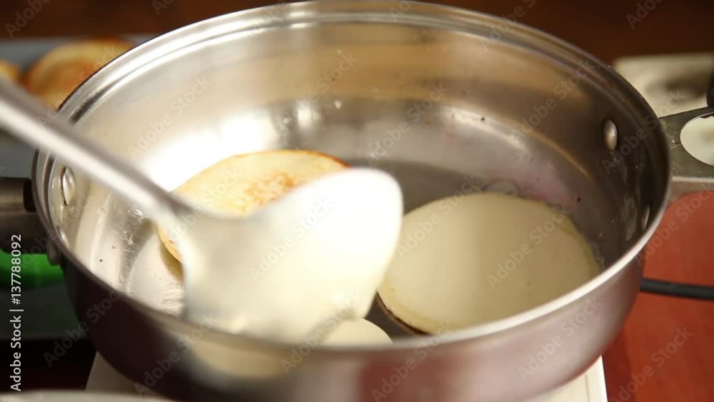 cook prepare breakfast or dessert, fry pancakes on a gribble. Homemade sweet pancakes with fruit jam, sour cream on a white plate. cook prepare breakfast or dessert, fry pancakes on a gribble. Homemade sweet pancakes with fruit jam, sour cream on a white plate.