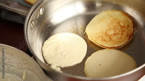 cook prepare breakfast or dessert, fry pancakes on a gribble. Homemade sweet pancakes with fruit jam, sour cream on a white plate. photo