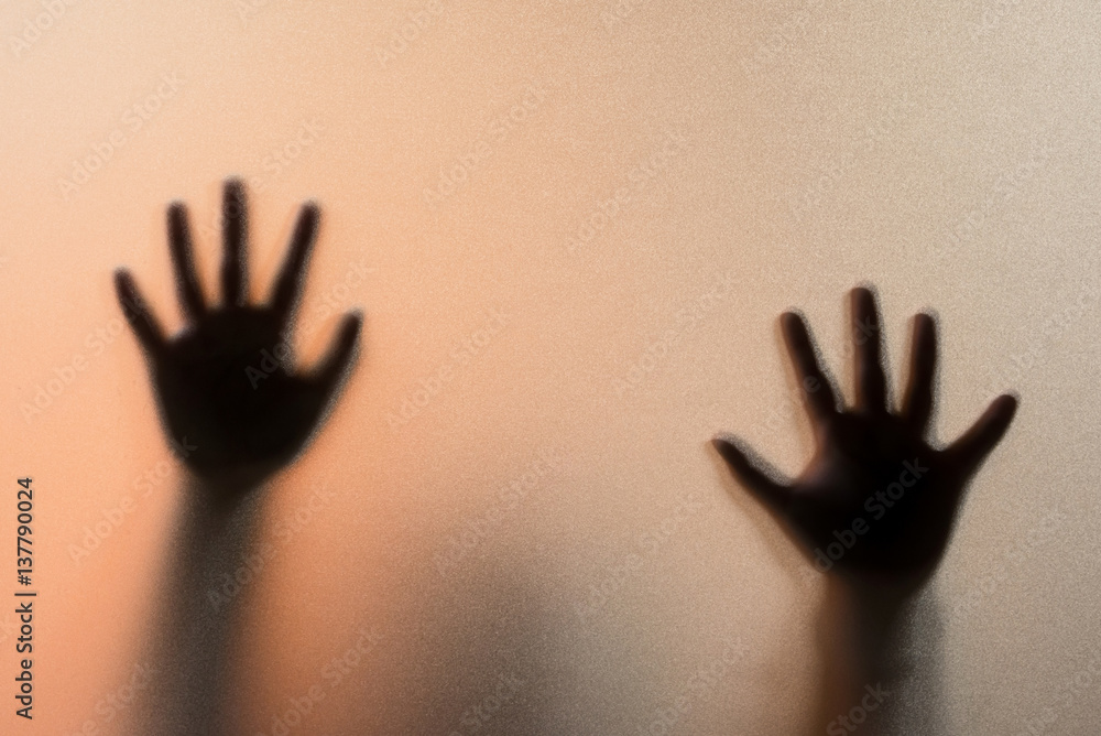 Shadow blur hands of the Man behind frosted glass.Blurry hand abstraction.Halloween background. Shadow blur hands of the Man behind frosted glass.Blurry hand abstraction.Halloween background.