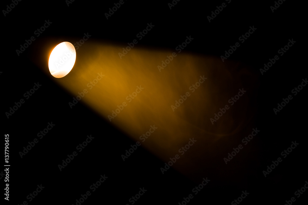 Authentic beam of light from reflector in theatre, smoke colored on yellow, orange and red colours.