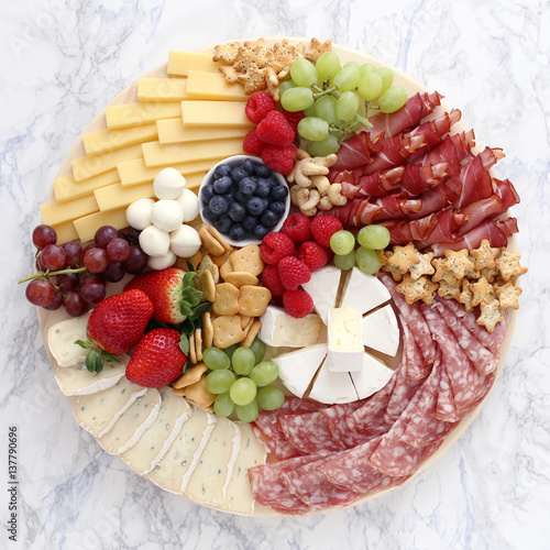 Cheese platte with ham, salami and fruits  photo