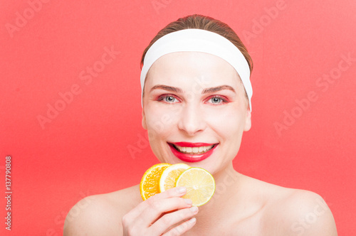 Beautiful smiling girl with three slices of lemon