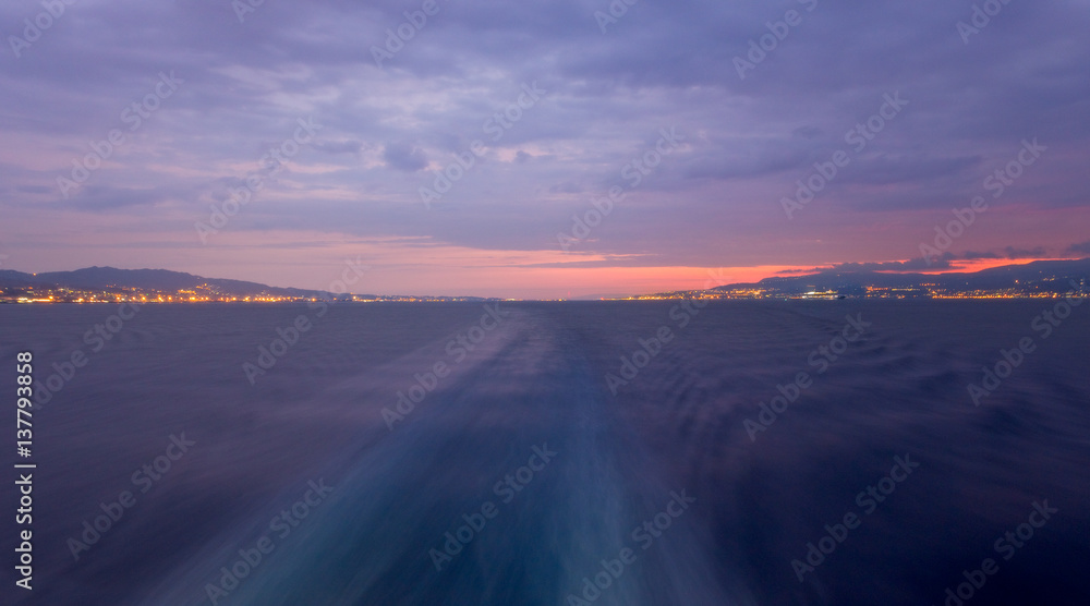 Italy's narrow and busy Strait of Messina, separating Sicily and Calabria, during a cloudy sunrise