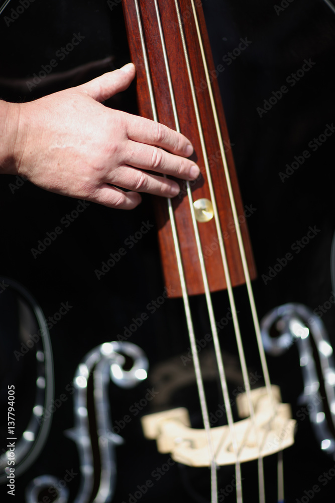 Musician's hand on the strings contrabass Musician's hand on the strings contrabass