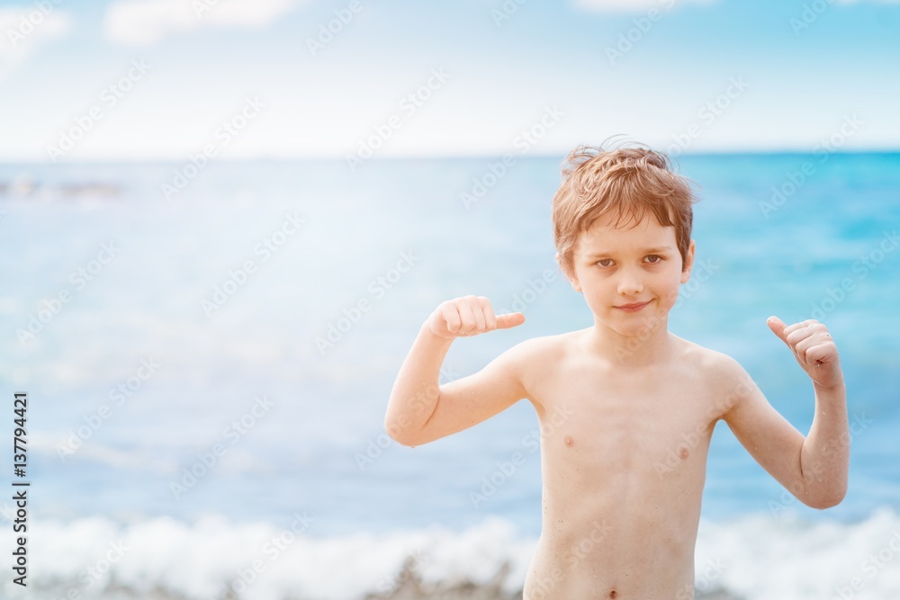 Happy 7 years boy in victory success gesture on the beach. Happy 7 years boy in victory success gesture on the beach.