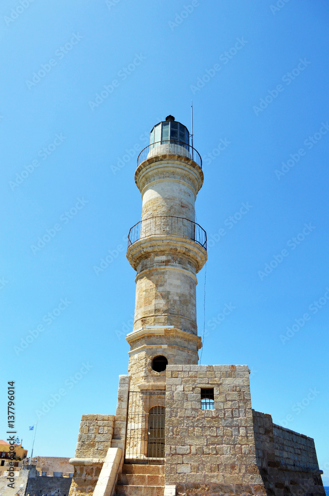 Lighthouse in city of Chania, Crete, Greece. Old stone lighthouse settled in front of the entrance into port. The lighthouse saved many lives because a big rocks and waves are all around Chania.  