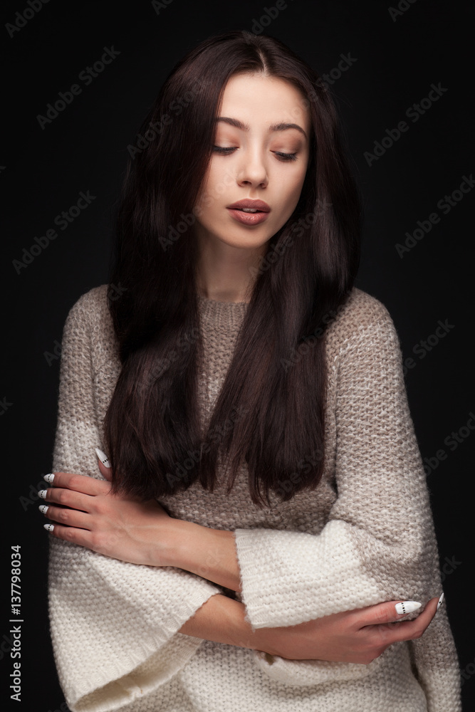 portrait of young elegant woman with long brown hair wearing knitted sweater on black background portrait of young elegant woman with long brown hair wearing knitted sweater on black background