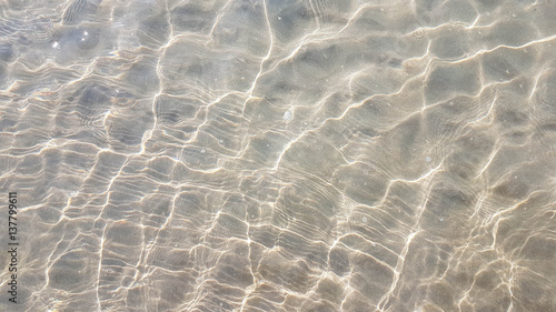 Wave of the sea with bubble and sunlight effect on sand beach