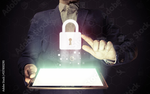 Image of a man with a tablet in his hands. He pointing to padlock icon as online and virtual security concept.