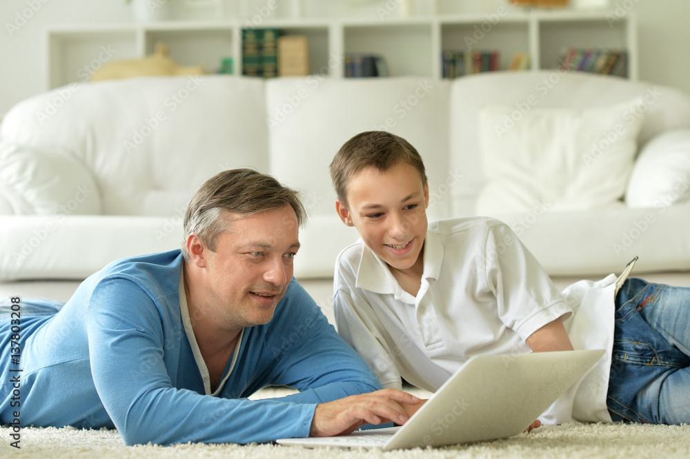 son and father using laptop