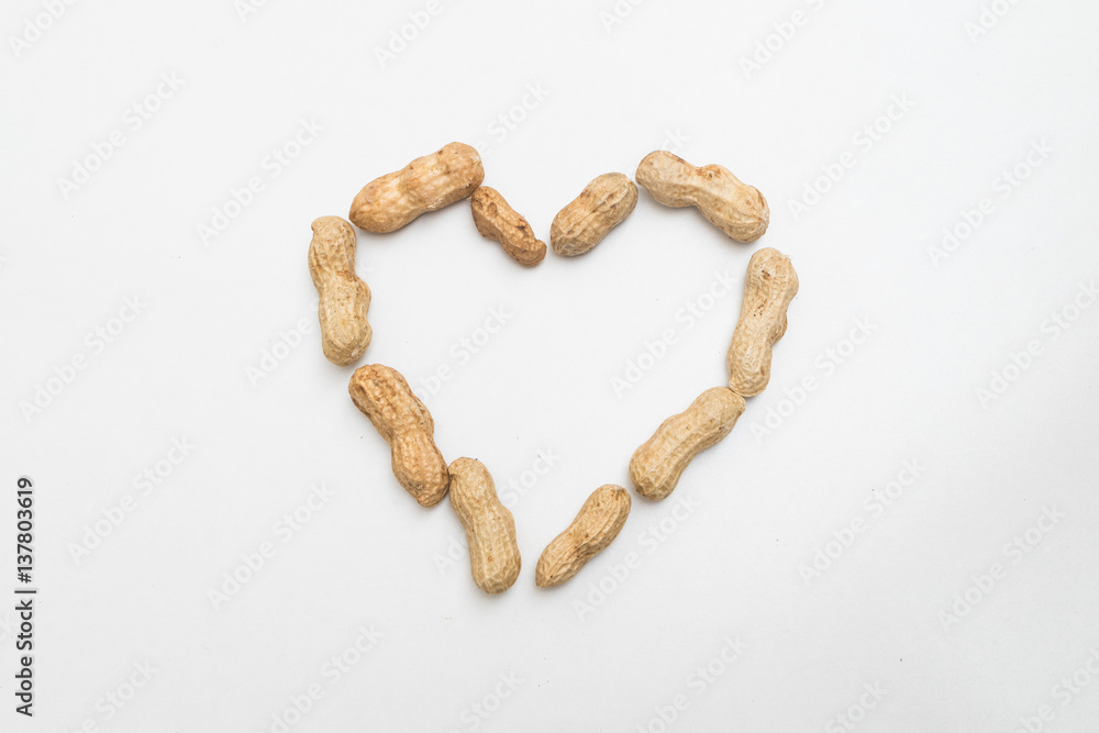 Fototapeta premium closeup peanut made in heart shape on white background