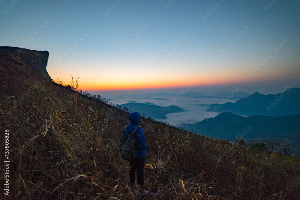 Man traveller standing looking beautiful mist at sunrise