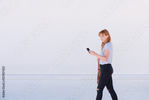 beautiful young woman walking with mobile phone