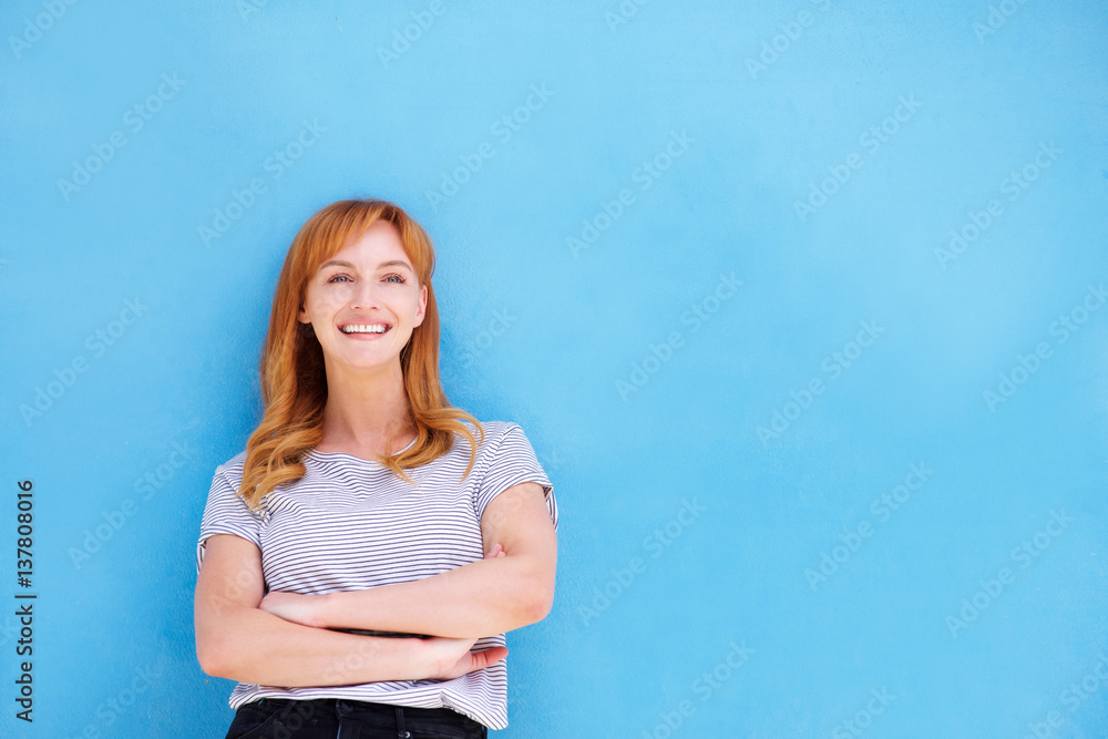 happy woman standing against blue wall happy woman standing against blue wall