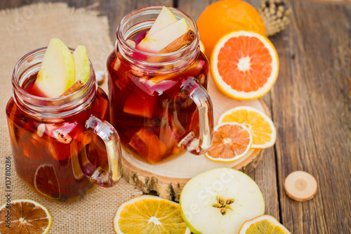 Mulled wine in glass mug with spices and citrus fruit