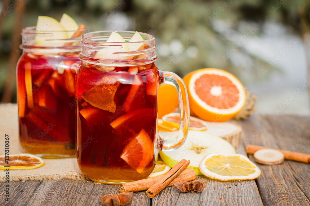 Mulled wine in glass mug with spices and citrus fruit Mulled wine in glass mug with spices and citrus fruit