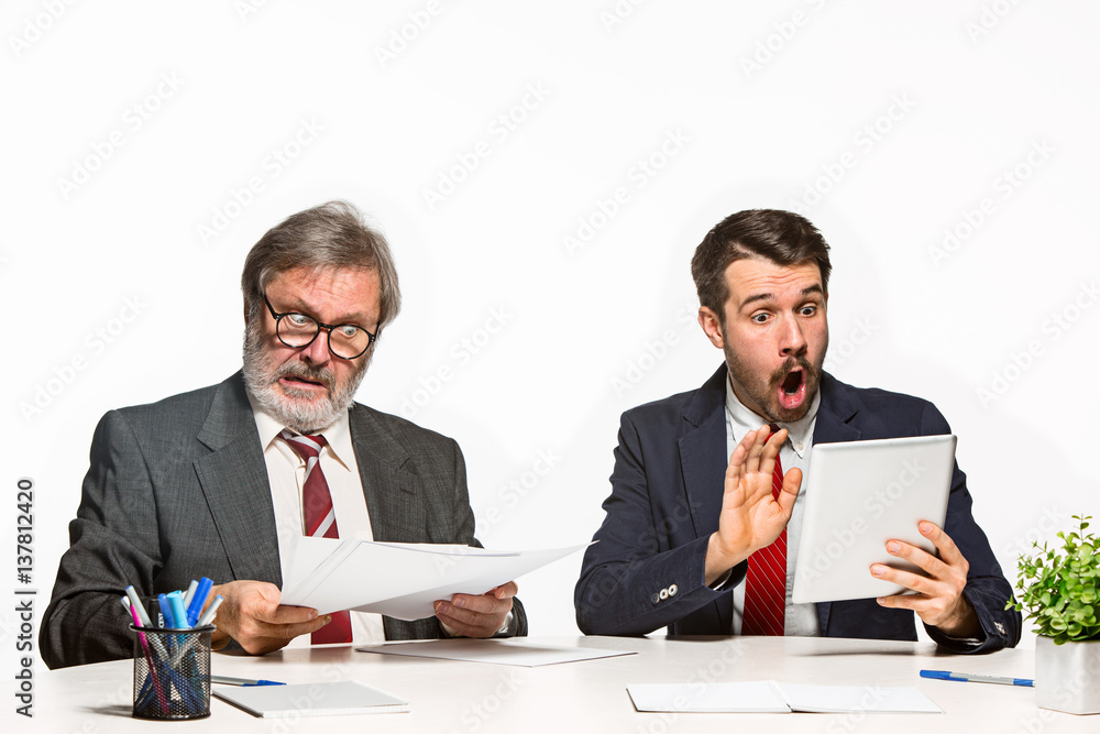 The two colleagues working together at office on white background. The two colleagues working together at office on white background.