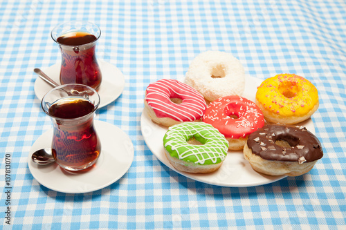 cups of tea and a donut on a blue table photo