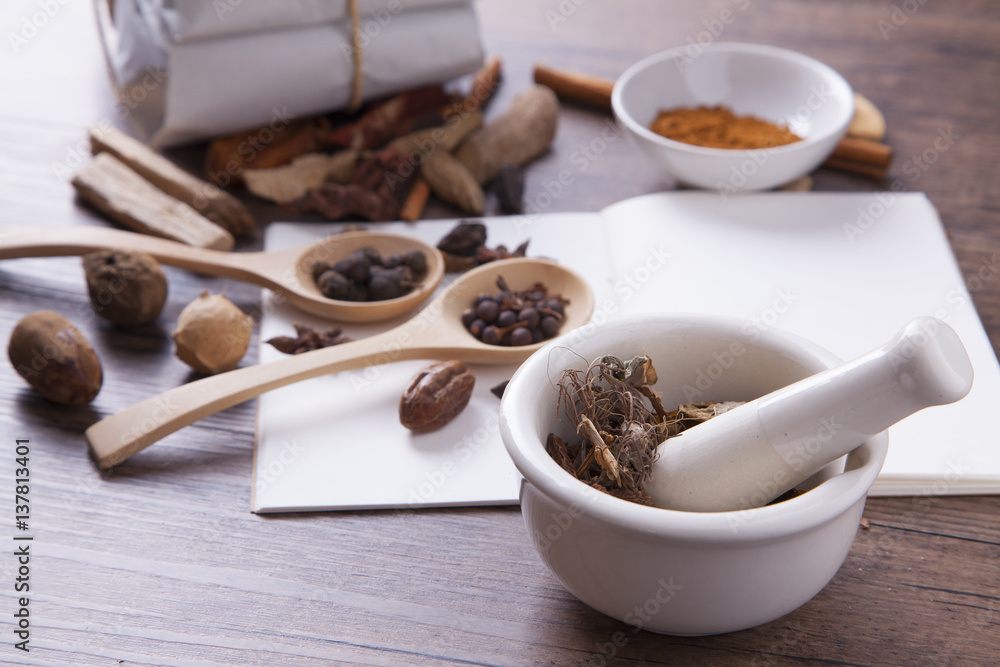 White mortar and herbal medicine on the wood table with studio light White mortar and herbal medicine on the wood table with studio light