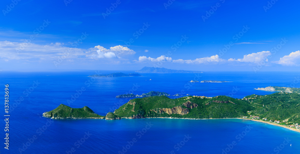 Naklejka premium Beautiful summertime panoramic seascape. View of the cliff into the crystal clear azure sea bay and distant islands. Agios Stefanos cape. Afionas. Corfu. Greece.