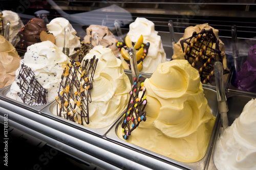 Esposizione di gelati di vari gusti nella vetrina refrigerata del  banco frigo photo