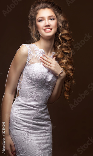 Beautiful Bride portrait wedding makeup and hairstyle with long curly tress, fashion bride model jewelry and beauty girl face, gorgeous beauty bride, isolated , studio. Chocolate background.