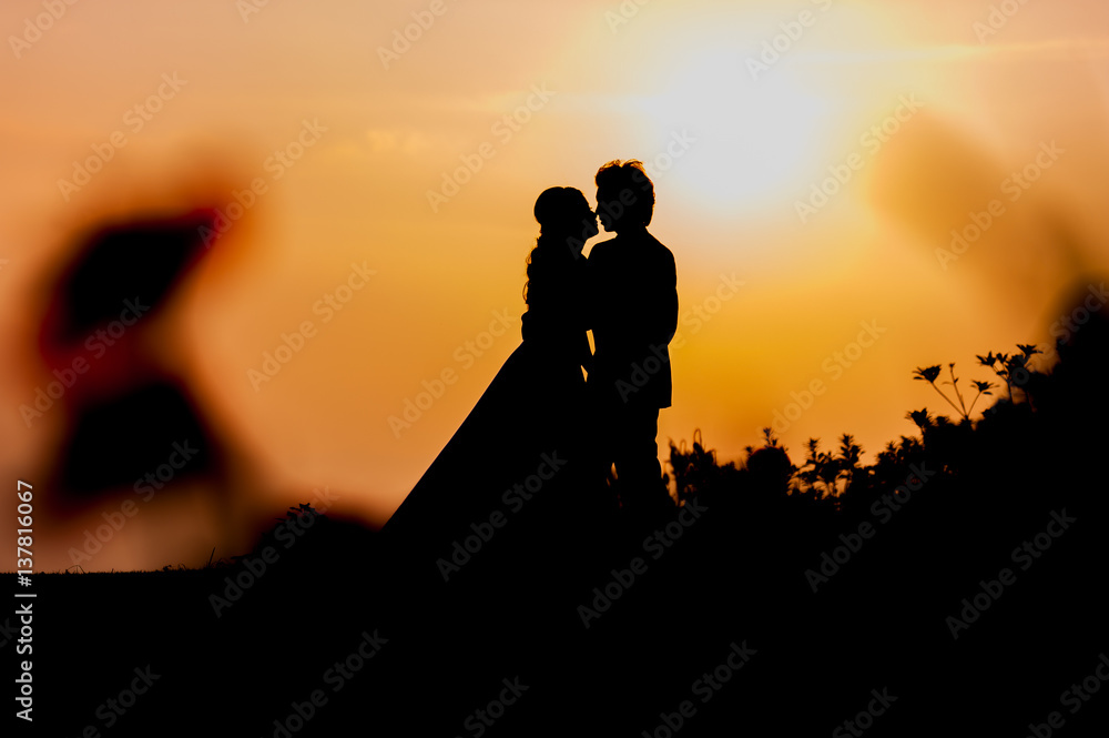 Silhouette of Asian Bride and Groom Standing on Mountain at Sunset