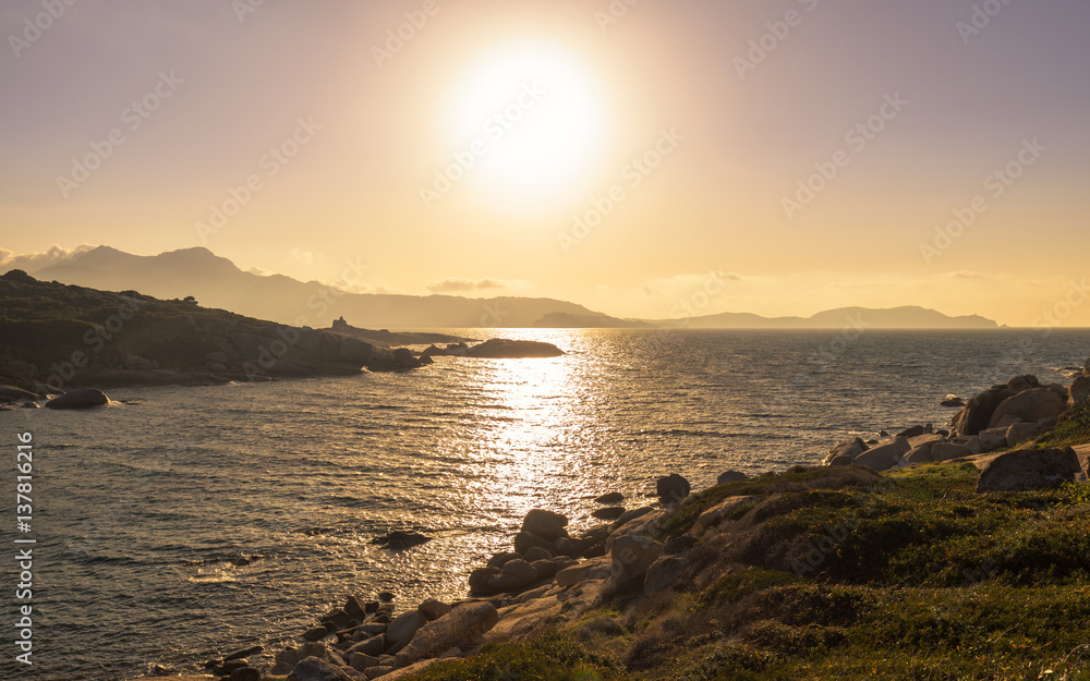 Fototapeta premium Sun setting over a Genoese tower and Calvi in Corsica