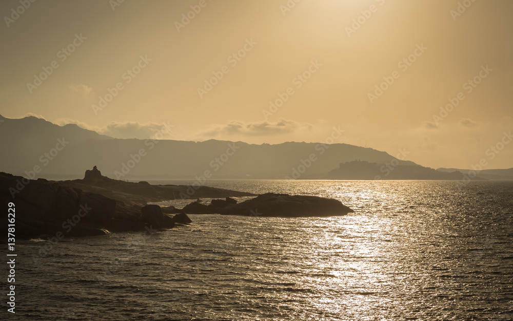 Sun setting over a Genoese tower and Calvi in Corsica Sun setting over a Genoese tower and Calvi in Corsica