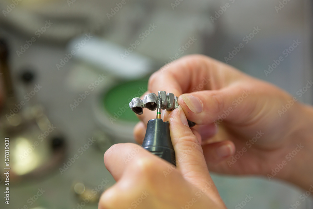 Fototapeta premium Technician polishing or grinding dental implant