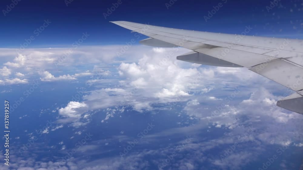 Vibrant cloudscape view through ice glazed aircraft window on blue sky and airplane wing. Traveling by air above beautiful clouds. 4k Ultra HD 3840x2160
Vibrant cloudscape view through ice glazed aircraft window on blue sky and airplane wing. Traveling by air above beautiful clouds. 4k Ultra HD 3840x2160