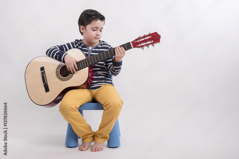 nino tocando la guitarra foto de Stock Adobe Stock