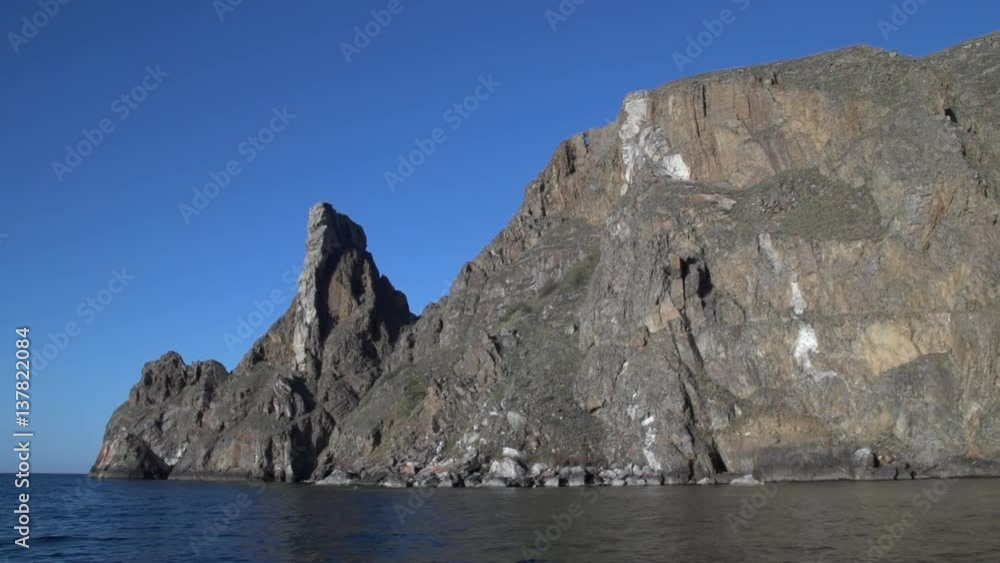 View from the water on the rock Olkhon - the largest island of Lake Baikal. Khoboy Cape - the northern cape on Olkhon island. View from the water on the rock Olkhon - the largest island of Lake Baikal. Khoboy Cape - the northern cape on Olkhon island.