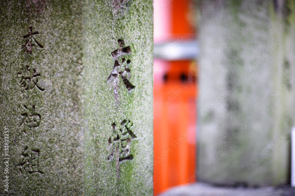 Element of ancient stone torii gate with fragments of ancient Buddhist ...