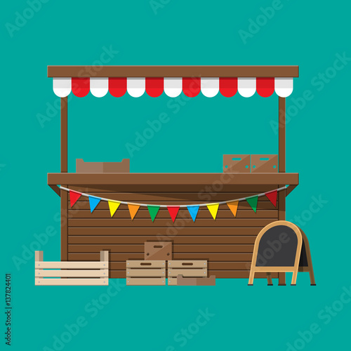 Market food stall with flags, crates, chalk board