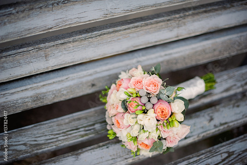 Beautiful bridal bouquet tied with silk ribbons . Roses and pions .