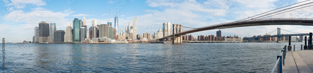 New York city skyline panorama and Brooklyn Bridge in a sunny day