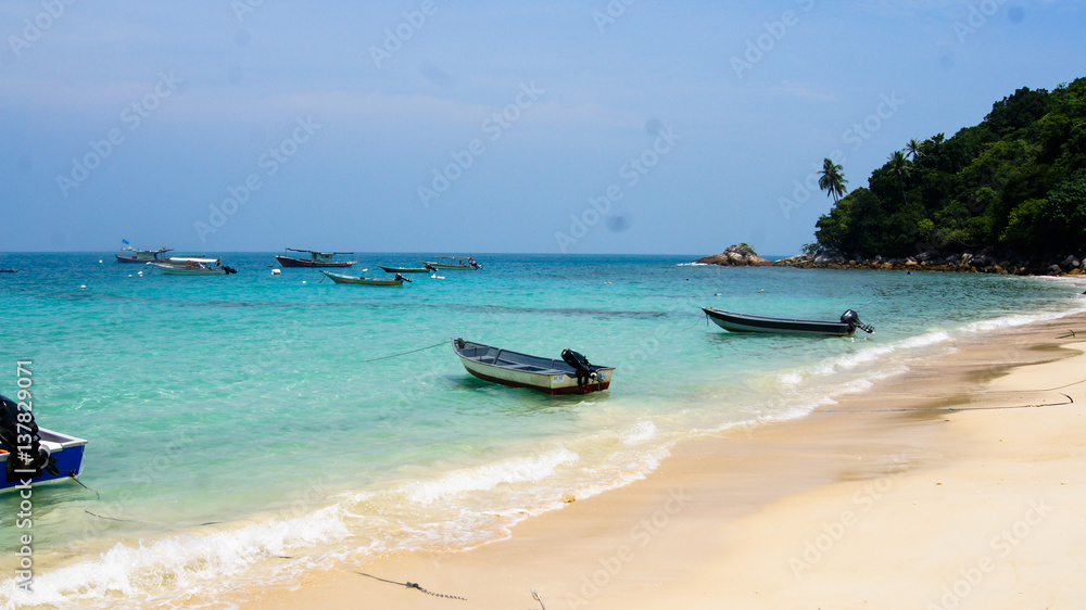 White sand beach with blue water and boats