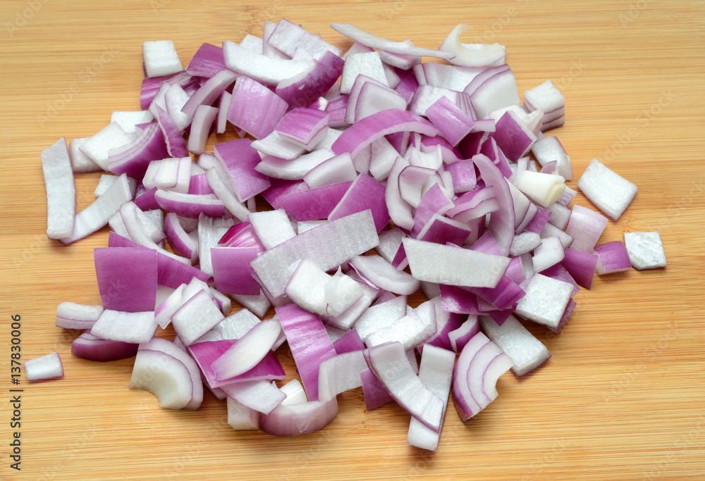 Sliced red onions on cutting wooden board background