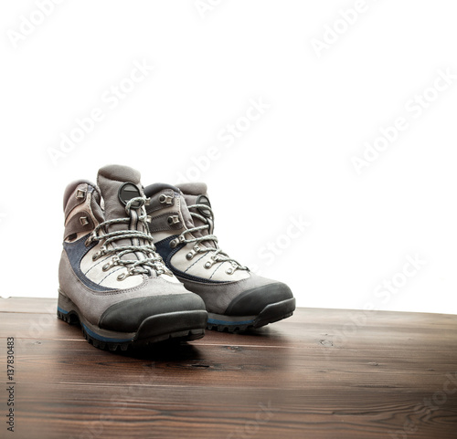 Pair of new hiking boots on wooden floor isolated