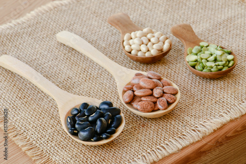 Multicolor dried legumes on wooden spoon