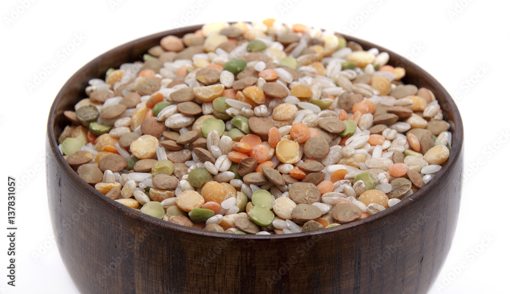 The mixture of different lentils and rice in a wooden bowl The mixture of different lentils and rice in a wooden bowl