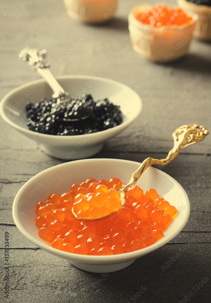 Black and red caviar tartlets, appetizer canapes in white bowls Black and red caviar tartlets, appetizer canapes in white bowls