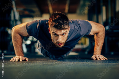 Konstfotografi Handsome man doing pushups in the gym