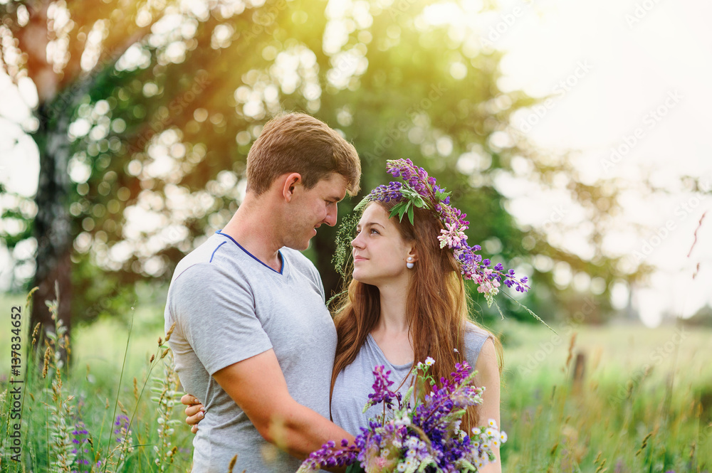 beautiful young couple in the spring garden with a bouquet of wildflowers beautiful young couple in the spring garden with a bouquet of wildflowers
