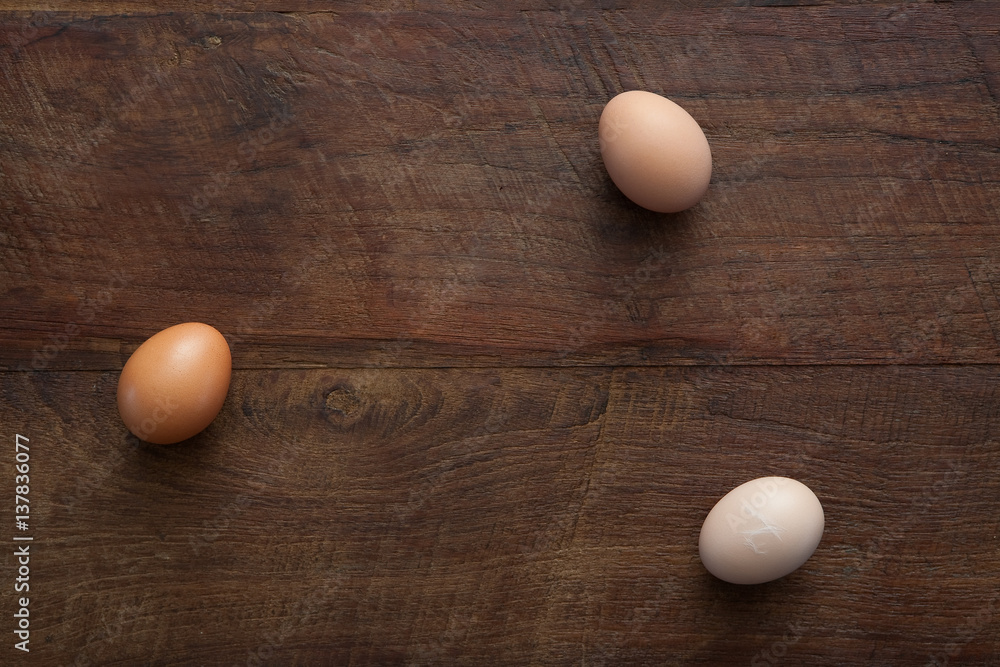 Three Farm Fresh Chicken Eggs Horizontal Flat Lay on Brown Rustic Wooden Farm Table Three Farm Fresh Chicken Eggs Horizontal Flat Lay on Brown Rustic Wooden Farm Table