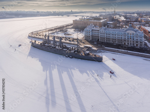 Russia, Saint-Petersburg, 10 February 2017: Aero shootings of a winter panorama monument of October revolution cruiser the Aurora at sunset, the Nakhimov Military Naval School, frozen river Neva photo