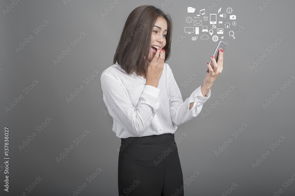 Beautiful business Woman using smartphone on grey background Beautiful business Woman using smartphone on grey background
