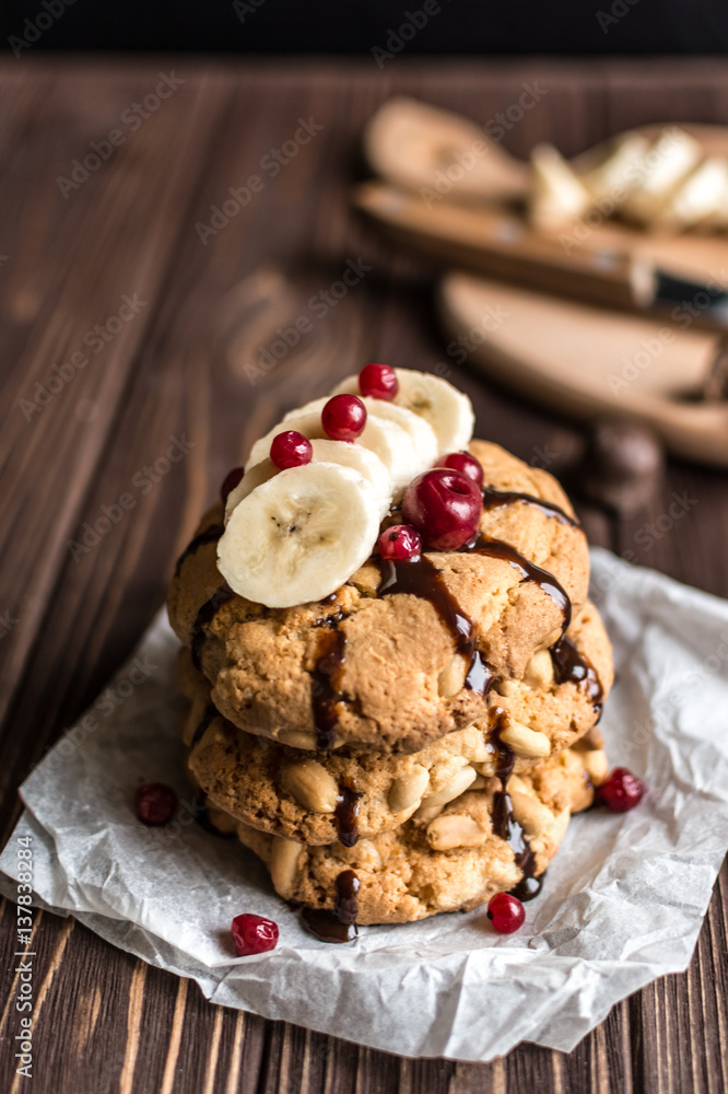Peanut cookies with banana and berries on a wooden background Peanut cookies with banana and berries on a wooden background