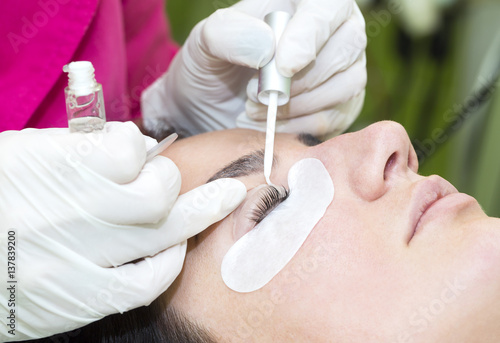 Woman on the procedure for eyelash extensions, eyelashes lamination  photo